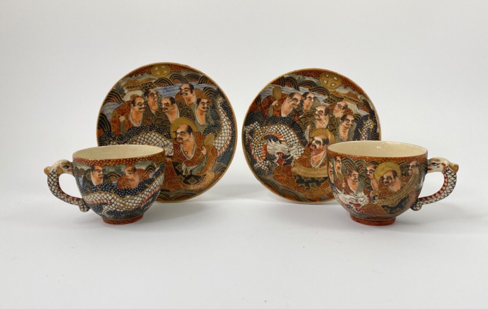 Satsuma pottery cups and saucers, ‘Thousand faces’ and dragons.Meiji Period.